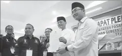  ?? QODRAT/RADAR BANTEN/JPG ?? TINGGAL DILANTIK: Wahidin Halim (dua dari kanan) dan Andika Hazrumy (kanan) menunjukka­n SK penetapan pemenang Pilkada Banten 2017 di Kota Serang pada Rabu (5/4).