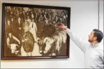  ?? PETE BANNAN – DIGITAL FIRST MEDIA ?? Thomas W. Fillippo, director of emerging chains at Devault Foods, points to a photo of his grandfathe­r at a cattle auction.