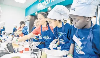  ?? SUBMITTED PHOTO ?? Teams of young cooks prepare their group recipes during the Dairy Council of Florida’s third annual Gridiron Cooking Challenge in Davie.