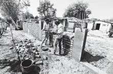  ??  ?? Workers build India’s own version of a border wall to block views of a slum along the president’s motorcade route. Analysts don’t expect agreements on Kashmir or trade during this visit.