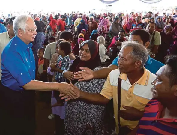  ?? BERNAMA PIC ?? Prime Minister Datuk Seri Najib Razak being greeted as he arrives at an event to hand out aid to padi farmers in Merchong Jaya, Pekan, yesterday.