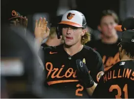  ?? NICK WASS/AP ?? Gunnar Henderson is congratula­ted in the dugout after he scored on a double by Robinson Chirinos during the third inning Friday night. Henderson went 2-for-4 with two doubles in his home debut at Camden Yards.