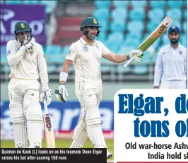  ??  ?? Quinton de Kock (L) looks on as his teamate Dean Elgar raises his bat after scoring 150 runs