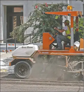  ?? File photo ?? Constructi­on: Workers use machinery to construct the Murphy Arts District (left) and repaving the roads around the square downtown in El Dorado (right).