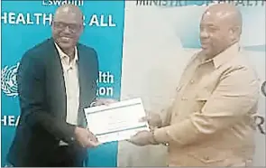  ?? (Pics: Sabelo Ndzinisa) ?? Ministry of Health officer and former Premier League of Eswatini football player Brian Cindzi (L) receiving his certificat­e from the minister.