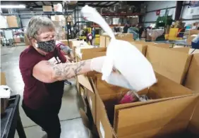  ?? AP PHOTO/CHARLES REX ARBOGAST ?? Volunteer Linda Nordin places a meat package into a box with other food at the Northern Illinois Food Bank to be delivered by DoorDash drivers for area residents who are homebound on Nov. 10 in Park City, Ill.