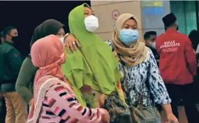  ?? TATAN SYUFLANA/AP ?? Relatives of passengers on a Sriwijaya Air passenger jet arrive at a crisis center after a report the jet was lost after takeoff in Indonesia on Saturday.