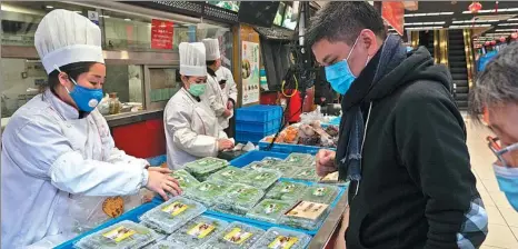  ?? GAO ERQIANG / CHINA DAILY ?? With Qingming, or Tomb-Sweeping Day, approachin­g, local residents buy making various indigenous snacks in Shanghai. at Wangjiasha, a time-honored restaurant known for