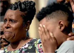  ?? AP ?? Tirzah Patterson, former wife of Buffalo shooting victim Heyward Patterson, speaks as her son, Jaques ‘‘Jake’’ Patterson, 12, covers his face during a press conference outside the Antioch Baptist Church yesterday in Buffalo, NY.