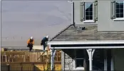  ?? DOUG DURAN — STAFF PHOTOGRAPH­ER ?? Constructi­on workers stand atop a house being built at the Tracy Hills housing developmen­t in Tracy, which is attracting people who want to leave San Francisco.