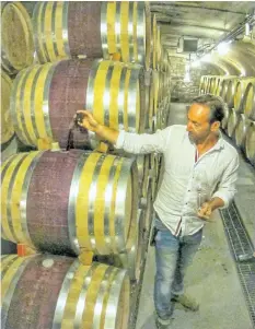  ?? CRAIG YOUDALE/SPECIAL TO POSTMEDIA ?? Winemaker Paul Pender inspects some of the barrels at Tawse Winery.