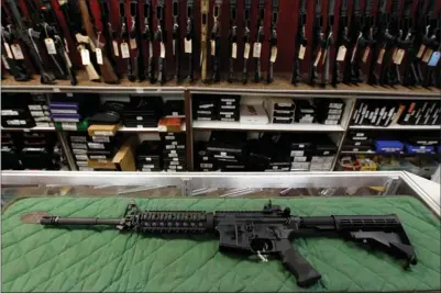  ??  ?? In this July 26 photo, an AR-15-style rifle is displayed at the Firing-Line indoor range and gun shop in Aurora, Colo. Demand for firearms, ammunition and bulletproo­f gear has jumped since the Dec. 14 school shooting in Newtown, Conn., that killed 20...