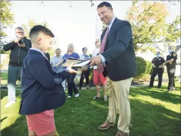  ?? Brian A. Pounds / Hearst Connecticu­t Media ?? Above, Make-A-Wish recipient Anthony Muoio, 7, of Milford, receives a proclamati­on from Mayor Ben Blake during a city ceremony and WPLR radio interviews on the Green in Milford on Thursday. For his wish, Anthony, a brain tumor survivor, will receive a camper for his family. At right, Anthony gets an impromptu lift from former profession­al wrestler and Micalizzi’s Italian Ice owner Jay Piccirillo.