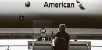  ?? Josh Richie / New York Times ?? An American Airlines employee assists a traveler at Miami Internatio­nal Airport. After months of staying at home during the pandemic, Americans are heading to U.S. vacation destinatio­ns.