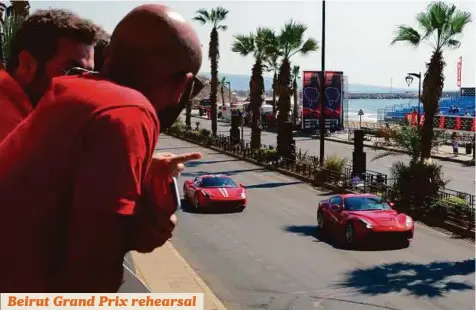  ?? AP ?? Men watch a rehearsal of a race titled the Beirut Grand Prix at the Ramlet Al Bayda public beach in Beirut on Saturday, a day before the race is scheduled to take place near the Lebanese capital’s coast. The Beirut Grand Prix is the first supercar...