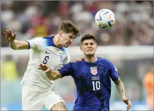 ?? LUCA BRUNO — THE ASSOCIATED PRESS ?? England’s John Stones vies for the ball with Christian Pulisic of the United States, right, during their World Cup group B match Friday at the Al Bayt Stadium.