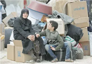  ?? — AFP ?? A Syrian boy who was evacuated from the rebel-held town of Harasta in Eastern Ghouta looks at a woman in a camp for displaced people in Maaret al-ikhwan, in rebel-held Idlib province, on Thursday.