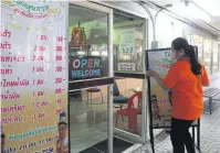  ?? SOMCHAI POOMLARD ?? A masseuse in Samut Prakan’s Muang district closes her shop to comply with disease control measures.
