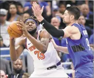  ?? John Raoux / Associated Press ?? The Knicks’ Mitchell Robinson, left, looks to pass the ball while guarded by the Magic’s Nikola Vucevic during the second half of Wednesday’s game.