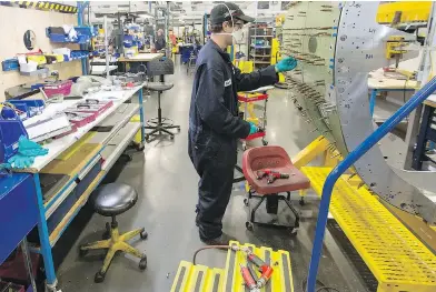  ?? ADRIAN LAM, TIMES COLONIST ?? Keith Cooper works on the belly of a new Twin Otter in the production area of Viking Air, where workers are back on the job after a three-month layoff.