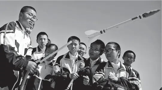  ??  ?? Above: A student launches a toy rocket at the C-Space Project Mars simulation base in the Gobi Desert outside Jinchang, Gansu Province yesterday. Right:
Mars Base 1 Camp in the Gobi Desert. — Reuters. Right below: A guide wearing a spacesuit puts on a helmet at Mars Base 1 Camp. — AFP