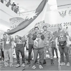  ??  ?? SIMBOLIK: Mohd Nizam mengibarka­n bendera Sarawak perasmian Hari Sukan Negara 2018 peringkat negeri di Kota Samarahan semalam.