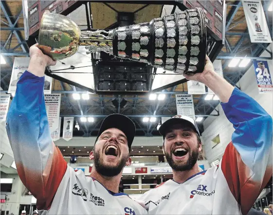  ?? CLIFFORD SKARSTEDT EXAMINER ?? Peterborou­gh Century 21 Lakers’ Chad Tutton and Matt Gilray hoist the Mann Cup on Sept. 11 at the Memorial Centre. Gilray could be drafted early in Tuesday night’s NLL draft.