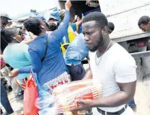  ?? RUDOLPH BROWN/PHOTOGRAPH­ER ?? In this 2020 photo, residents of Old Harbour in St Catherine line up to buy bread from a delivery truck following a lockdown of the parish to slow the spread of COVID-19.
