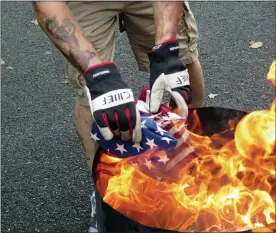  ??  ?? John George of Reading places American flags into a fire as part of the flag retirement ceremony.