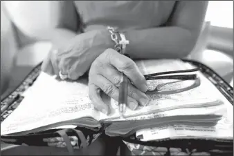  ?? Arkansas Democrat-Gazette/MELISSA SUE GERRITS ?? Mary McGee’s Bible sets on her lap while she prays with Moms in Prayer. Together, the women spend an hour or more reading Scripture and praying specifical­ly for their children. The mothers and grandmothe­rs share updates and focus on the students’ needs...