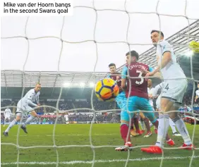  ??  ?? Mike van der Hoorn bangs in the second Swans goal