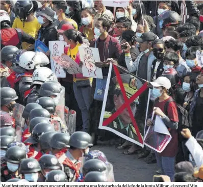  ?? Maung Lonlan / Efe ?? Manifestan­tes sostienen un cartel que muestra una foto tachada del jefe de la Junta Militar, el general Min Aung Hlaing, durante una protesta contra el golpe militar en Naypyidaw, Birmania.