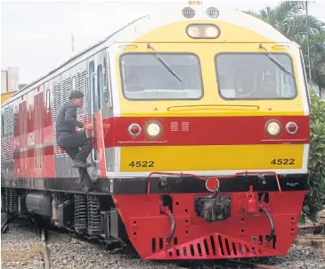  ?? THANARAK KHUNTON ?? A staff member climbs on board a new Chinese-made train which yesterday ran a special service from Bangkok to Nakhon Pathom. Prime Minister Prayut Chan-o-cha presided over the launch of the carriages at Hua Lamphong train station.