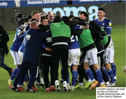  ??  ?? Cardiff’s players and staff go into a victorious huddle following their win at the Liberty Stadium