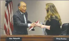  ?? BEA AHBECK/NEWS-SENTINEL ?? Incoming Mayor Alan Nakanishi is handed the gavel and is congratula­ted by City Clerk Jennifer M. Ferraiolo during the Lodi City Council meeting on Wednesday.
