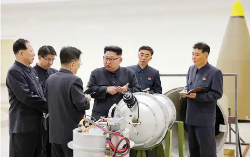  ?? Foto: dpa/KCNA ?? Staatschef Kim Jong Un (M) bei der Inspektion eines angebliche­n Wasserstof­fbomben-Sprengkopf­es an einem nicht genannten Ort