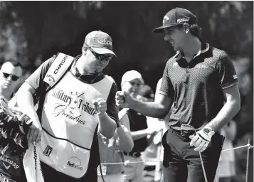  ?? Associated Press ?? ■ Kelly Kraft, right, gives his caddie a fist bump after a chip in birdie on the 11th hole during the third round of the Military Tribute at The Greenbrier golf tournament Saturday in White Sulphur Springs, W.Va.