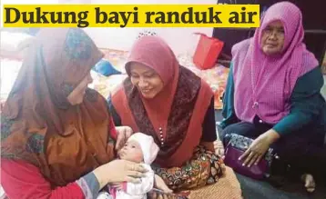  ??  ?? SALMI meriba bayinya sambil diperhatik­an jiran, Arinianti Abd Rahman (tengah) dan Zubedah Ahman.