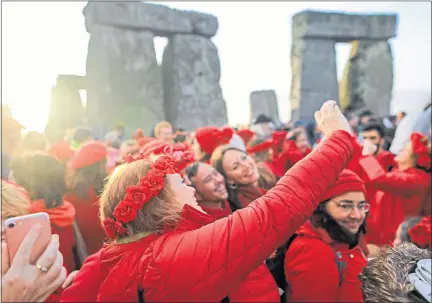  ??  ?? People taking selfies at Stonehenge and, below, at Eilean Donan Castle