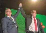  ?? Canadian Press photo ?? Outgoing Saskatchew­an Premier Brad Wall, left, lifts the arm of Scott Moe who won the party leadership and becomes the new Saskatchew­an Premier during the Saskatchew­an Party Leadership Convention in Saskatoon, Saturday.