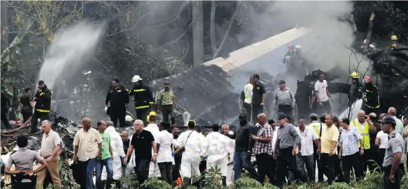  ?? ENRIQUE DE LA OSA / THE ASSOCIATED PRESS ?? Cuban President Miguel Diaz-Canel, third from left, assesses the site in Havana where a Boeing 737 plummeted into a yuca field Friday with more than 100 on board.