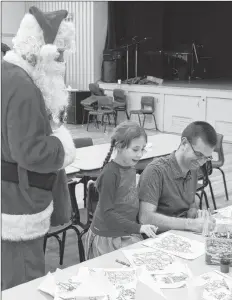  ?? SUBMITTED ?? Santa looks on as a father colours with his daughter at one of the craft tables.