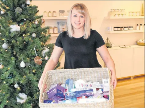  ?? KATIE SMITH/THE GUARDIAN ?? Jenna Thompson, owner of Luxe Beauty Bar in Charlottet­own, holds up a basket of hygiene products that have been donated. Donations can be dropped off at 79 Grafton St. until Dec. 20.