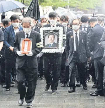  ?? AFP ?? Mourners carry a portrait of late Seoul mayor Park Won-soon during his funeral service at Seoul City Hall yesterday.