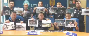  ??  ?? Tan (seated centre) and his officers show photograph­s of the raid at a press conference.