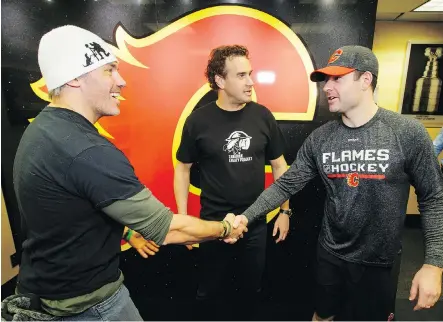  ?? LYLE ASPINALL ?? Former CFLer Chris Cvetkovic, left, founder of Cvet’s Pets, greets Flames goalie Brian Elliott, the man behind Moose’s Troops, on Wednesday at the Scotiabank Saddledome. Cvetkovic and Elliott both run programs designed to boost the morale of members of...