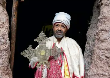  ??  ?? A priest prepares for a service in one of Lalibela’s undergroun­d churches.