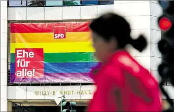  ?? DPA-BILD: SKOLIMOWSK­A ?? Eine Regenbogen­fahne mit der Aufschrift „Ehe für alle!“hängt über dem Eingang zur SPDParteiz­entrale im Willy-Brandt-Haus in Berlin.