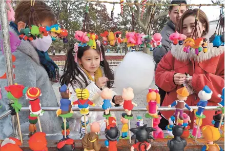  ??  ?? Customers at a downtown park during the sevenday Spring Festival holiday. Shanghai’s tourism market was injected with new momentum under the staycation trend as it recorded a combined 4.92 million visits over the seven days, 96 percent of the 2019 number. — Wang Rongjiang