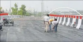  ?? BURHAAN KINU/HT PHOTO ?? Workers give finishing touches to a part of the 2km Barapullah Phase 2 stretch that will connect Jawaharlal Nehru Stadium with INA market.